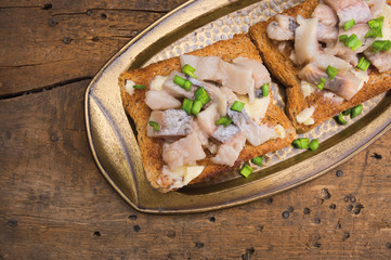 toast with herring in antique tray on old wooden table