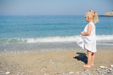 Little girl standing at the sea...