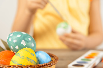 Fototapeta na wymiar Child paints egg for Easter, focus on eggs