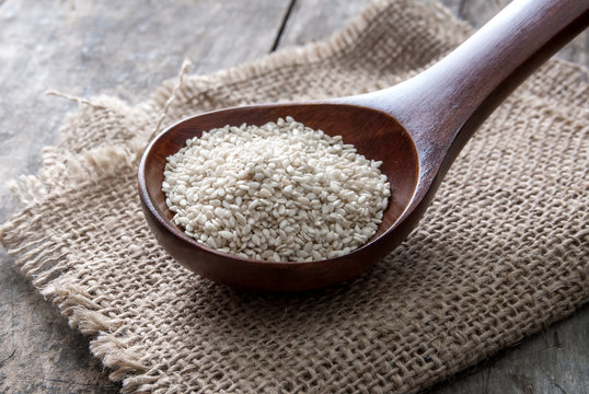 Organic natural sesame seeds on wooden spoon