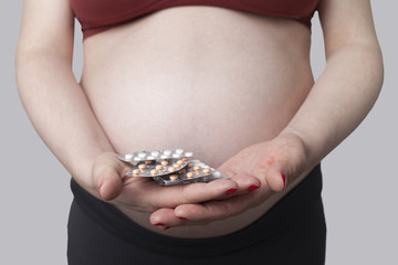 Pregnant woman holding pills