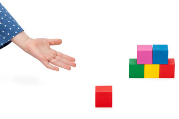 Obraz premium Child stretching left hand asking for a wooden block for a tower