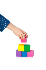 Fototapeta na wymiar Child's hand building a brick tower isolated on white background
