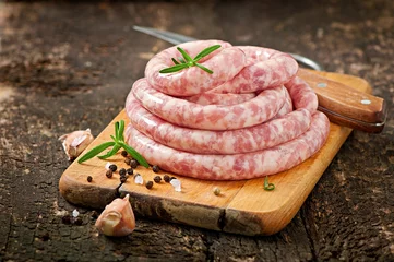 Foto op Plexiglas Fresh raw sausage on the old wooden background © timolina