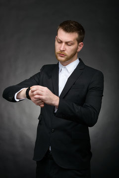 handsome young businessman looking at watch