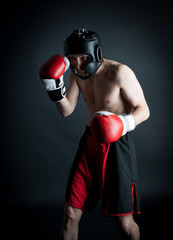 Man in helmet boxing in black background