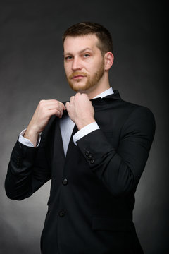 handsome confident business man in black suit