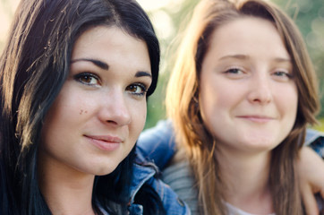 Two beautiful young friends posing arm in arm