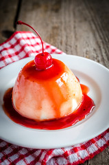Panna cotta with berry sauce and maraschino cherry