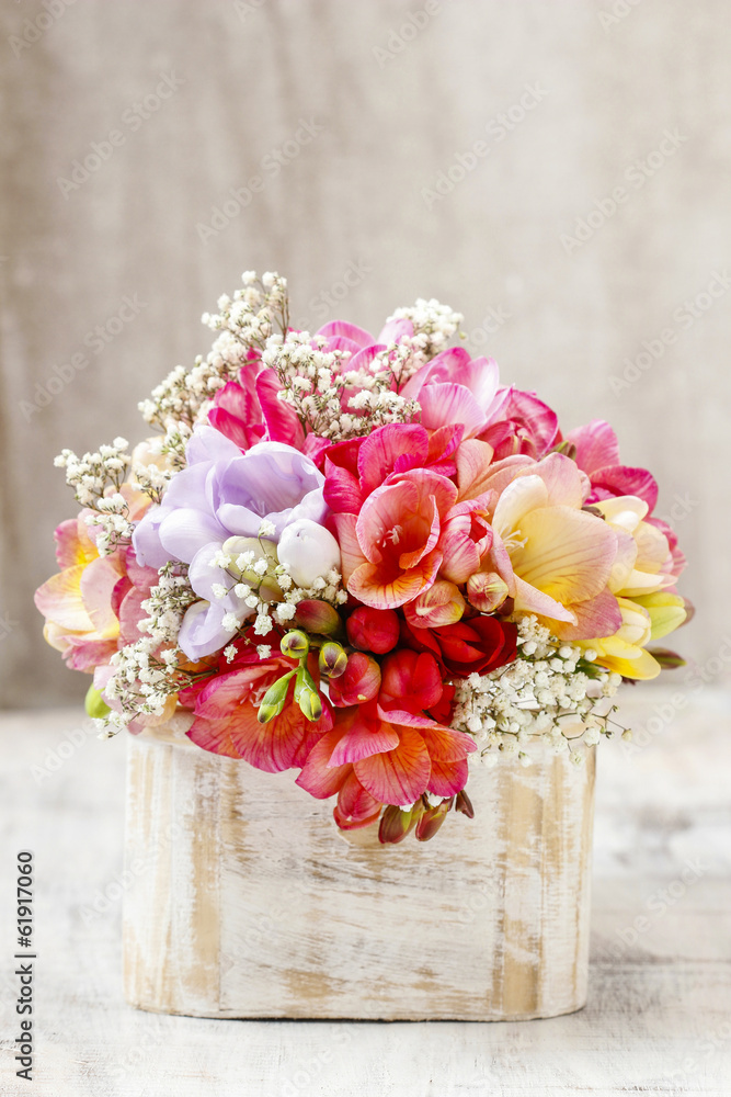 Canvas Prints Bouquet of colorful freesia flowers in wooden shabby chic box.