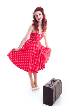 Beautiful retro pin-up girl with red dress and suitcase