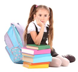 beautiful little girl, books and a backpack isolated on white