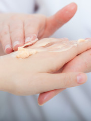 Obraz na płótnie Canvas Beautician applying moisturizing cream on client hands. Beauty.