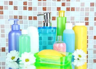 Obraz na płótnie Canvas Cosmetics and bath accessories on mosaic tiles background