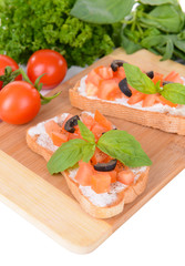 Delicious bruschetta with tomatoes on cutting board close-up