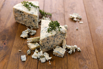 Tasty blue cheese with thyme, on wooden table