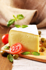 Tasty Camembert cheese with tomatoes, olives and basil,