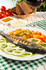 Delicious grilled fish on plate on table close-up