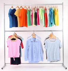 Different clothes on hangers, on gray background