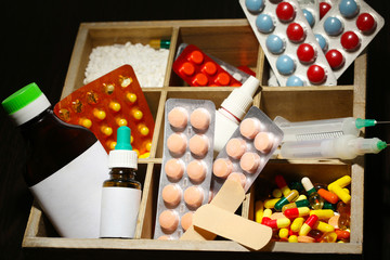 Medical pills, ampules in wooden box, on color wooden
