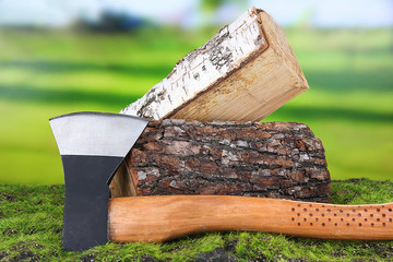 Ax and firewood on green grass, on nature background