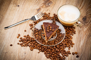 Cup of coffee latte and a cake on wooden table