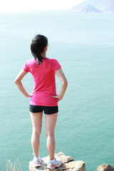 hiking woman stand at seaside mountain peak rock