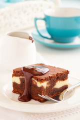 Chocolate brownie with cheese filling and chocolate sauce.