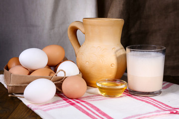 Obraz na płótnie Canvas Eggnog with milk and eggs on table and fabric background