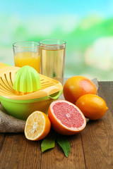 Citrus press and fruits on table on blue background