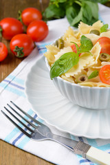 Delicious pasta with tomatoes on plate on table close-up