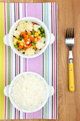 Cooked rice with vegetables on wooden table