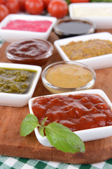 Various sauces on chopping board on table close-up