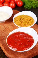 Various sauces on chopping board on table close-up