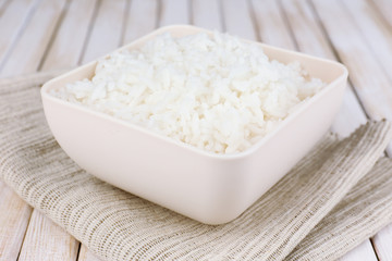 Cooked rice in bowl on wooden background