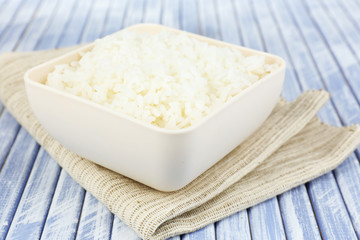 Fototapeta na wymiar Cooked rice in bowl on wooden background