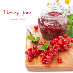 berry jam in a jar and fresh red currants on wooden board