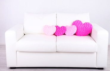 Pink heart shaped pillows on white sofa