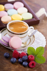 Coffee and French macaroons on a wooden background