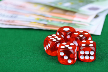 Red dices and money, on green background