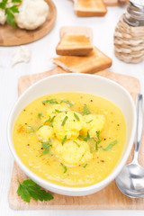 cauliflower soup with curry in a bowl, top view