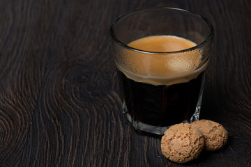 glass of espresso and almond cookies, close-up
