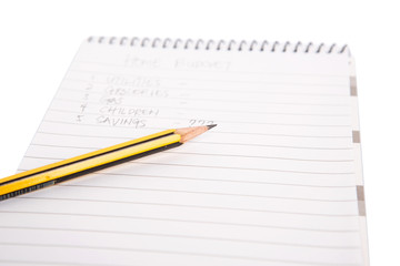 Concept image of home budget list on a notepad with pencil.