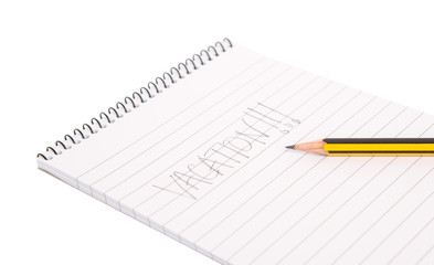 Concept image of the word vacation on a notepad with pencil