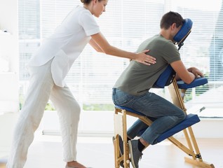 Female therapist massaging man in hospital