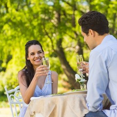 Couple toasting champagne flutes at an outdoor café