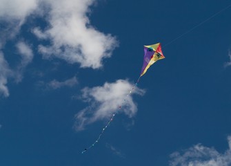 Fototapeta na wymiar Smiling kite on the blue sky with clouds