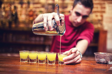 barman mixing and pouring a summer alcoholic cocktail
