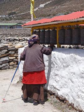 Femme âgée tournant les moulins à prière à Khumjung - Népal