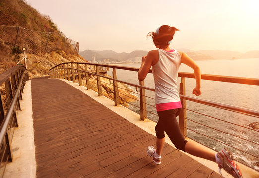 fitness  young woman running seaside wooden bridge